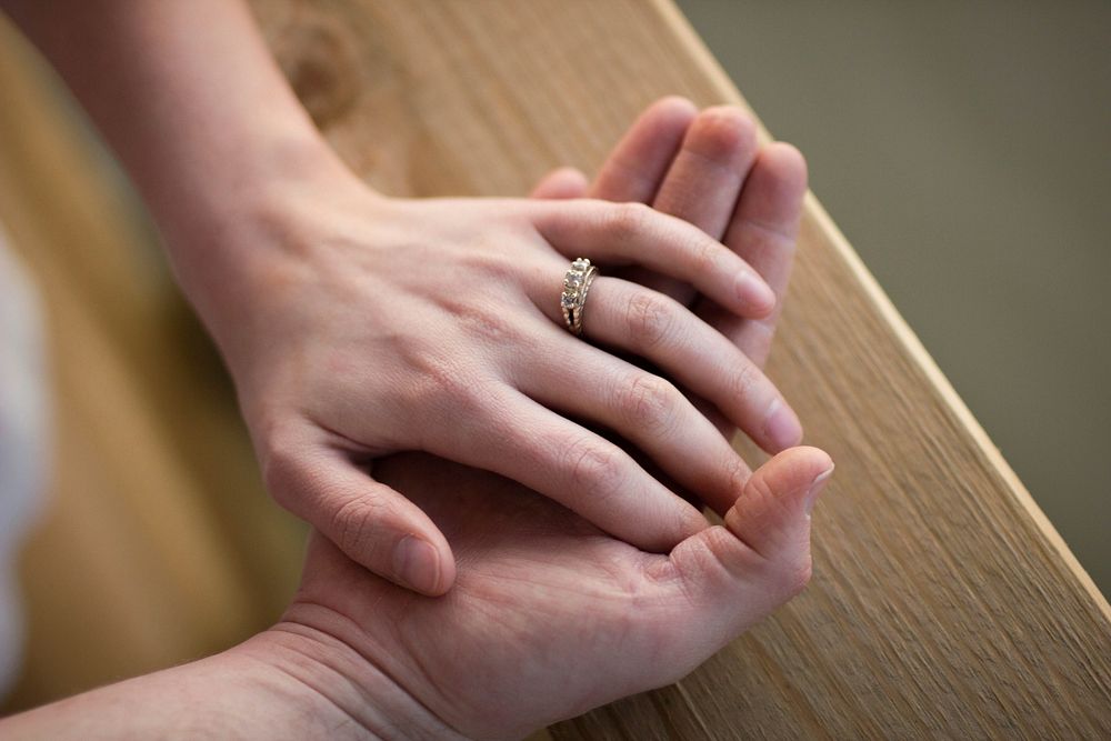 Bride's hand wearing wedding ring sits on groom's hand in Chattanooga. Original public domain image from Wikimedia Commons