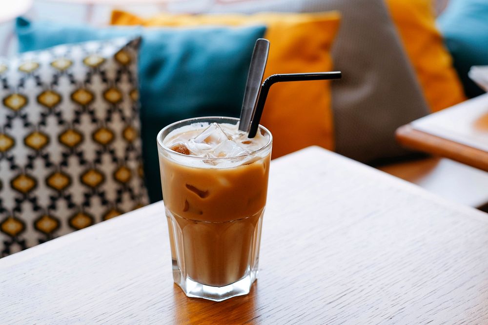 The macro view of a cup of latte with straw in it in Coupi bar. Original public domain image from Wikimedia Commons