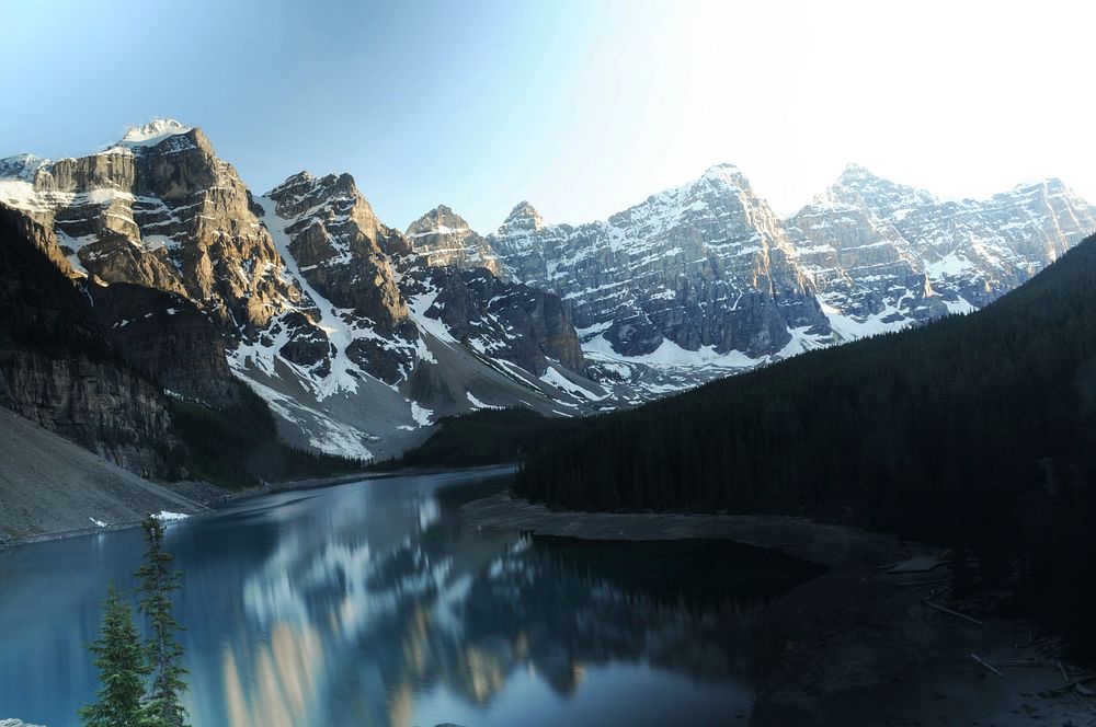 The Moraine Lake is showing a reflection of the snowcapped mountains surrounding it. Original public domain image from…