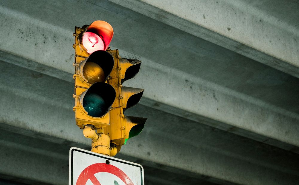 A traffic light showing a red light under a bridge. Original public domain image from Wikimedia Commons