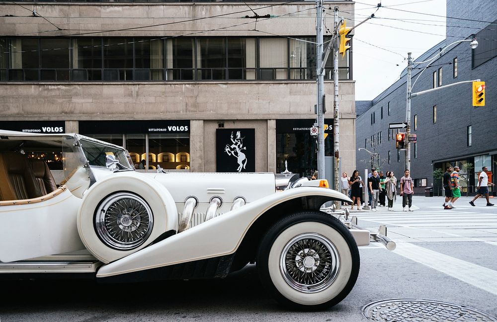 A white vintage automobile parked on the side of a Toronto street. Original public domain image from Wikimedia Commons