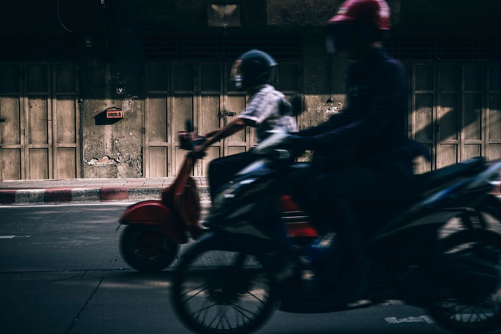 A blurry shot of a motorbike and a motor scooter next to each other on the street. Original public domain image from…