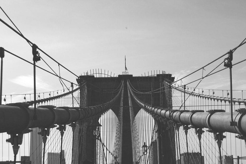 Black and white photo of the Brooklyn Bridge suspensions in New York City. Original public domain image from Wikimedia…