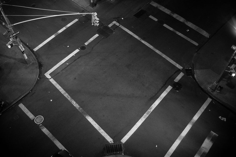 A look down at an empty intersection where traffic lines form a square. Original public domain image from Wikimedia Commons
