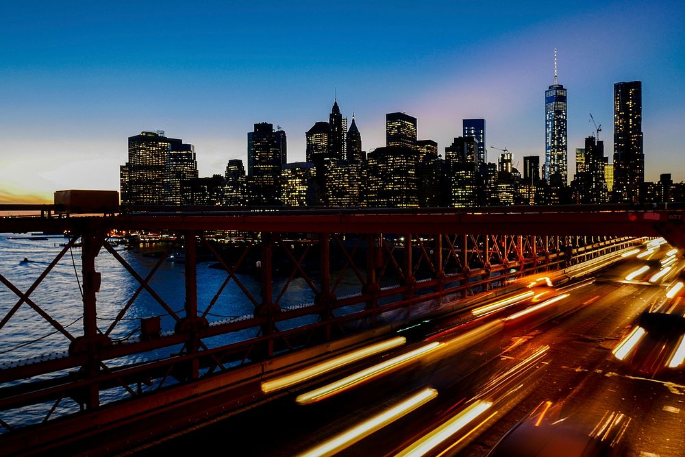 A long-exposure shot of light trails on the freeway with the New York city skyline at the back. Original public domain image…