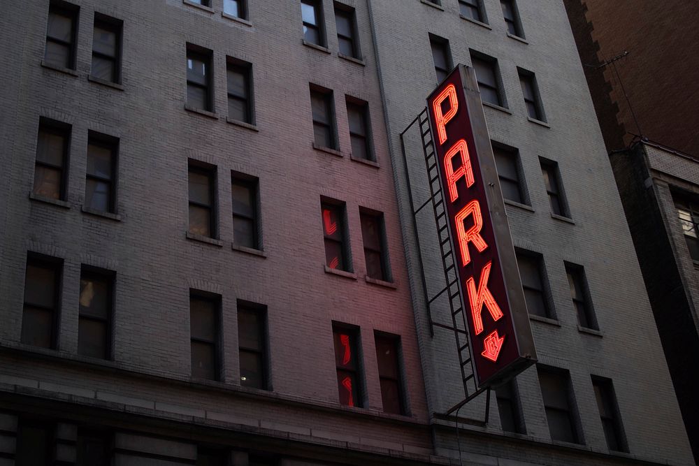 Neon sign reads "PARK" on a dark building in New York. Original public domain image from Wikimedia Commons