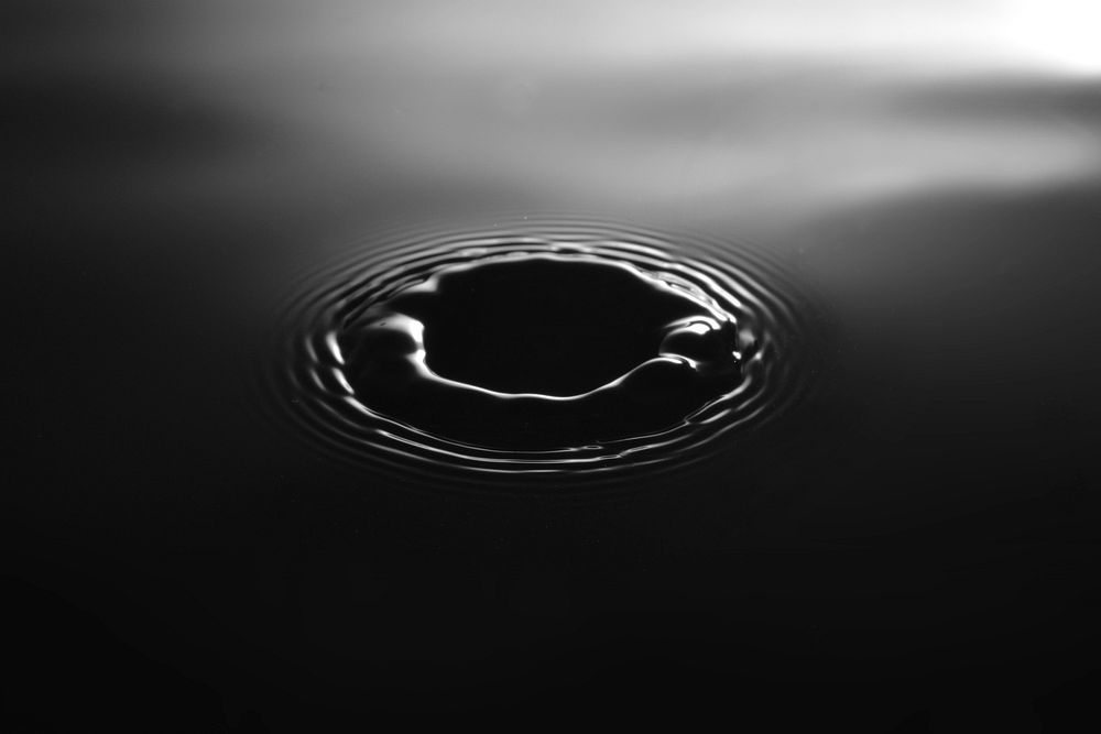 Black-and-white macro shot of a ripple in the surface of water. Original public domain image from Wikimedia Commons