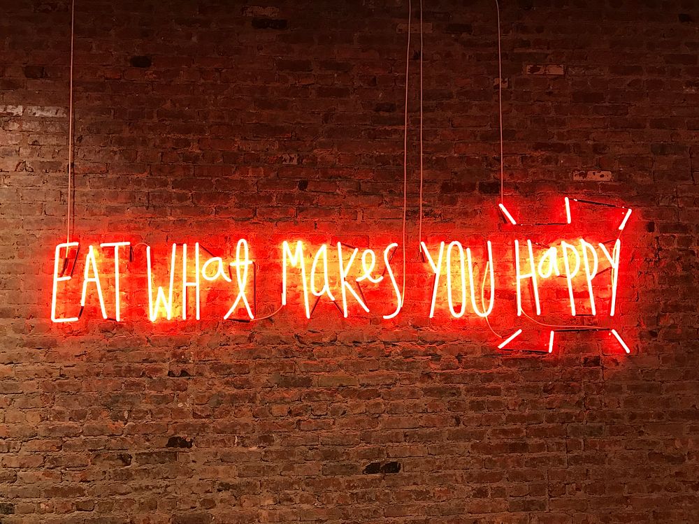 Lighted eat what makes you happy neon signage. Original public domain image from Wikimedia Commons
