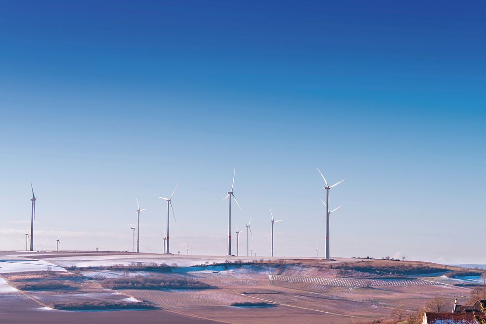 White wind turbine on gray desert under blue and white sky. Original public domain image from Wikimedia Commons