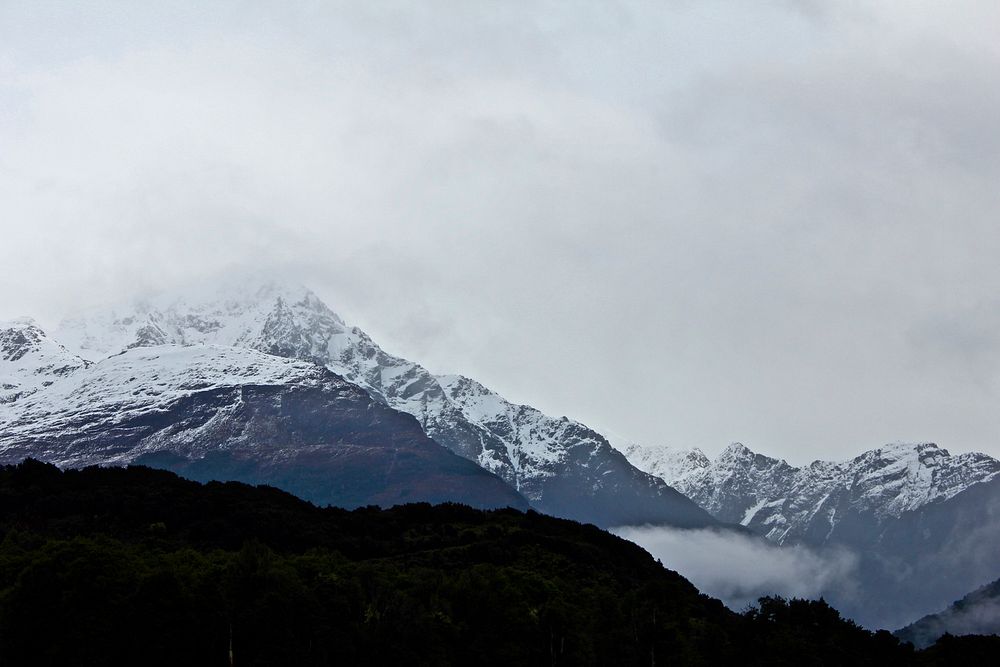 Snow-capped mountains fade into a foggy sky. Original public domain image from Wikimedia Commons
