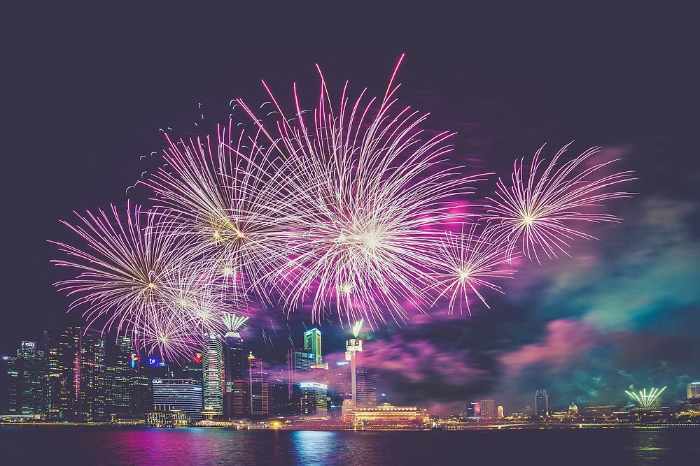 Pink fireworks in the city at night. Original public domain image from Wikimedia Commons