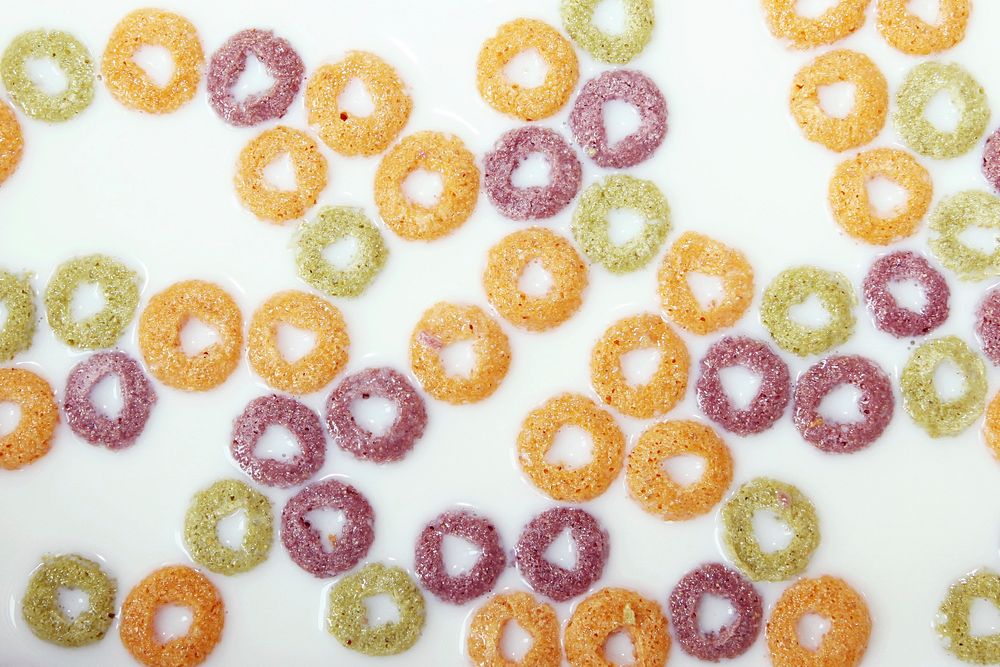 Colorful orange, green, and red cereals in a bowl of milk. Original public domain image from Wikimedia Commons
