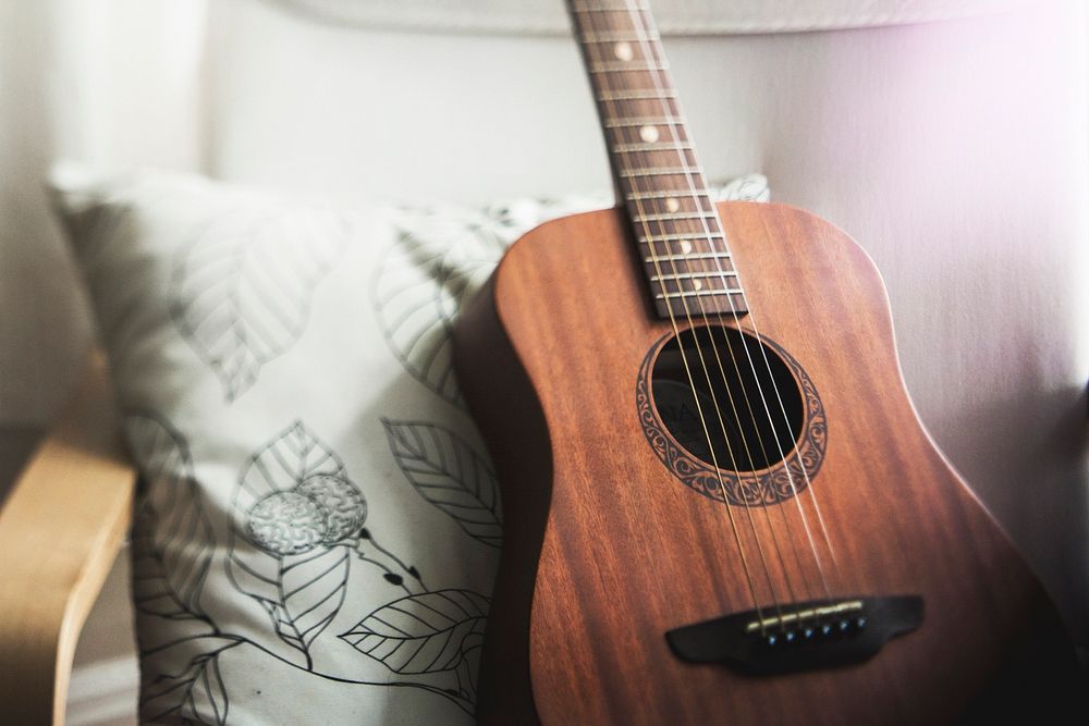 Guitar leaning against a pillow. Original public domain image from Wikimedia Commons