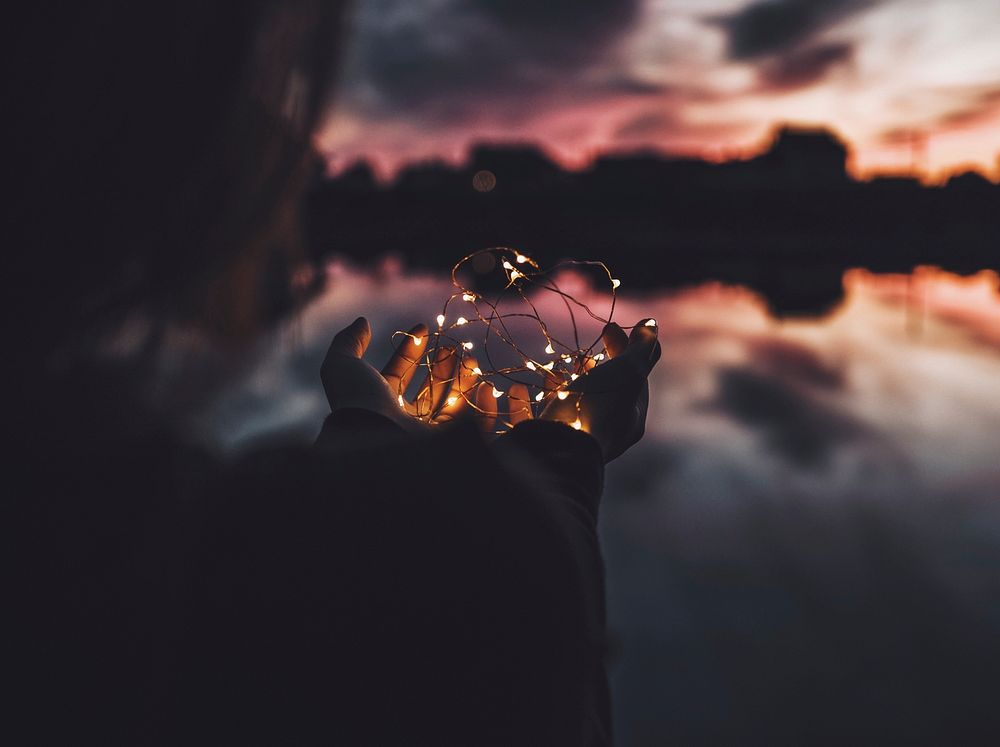 Woman holding a thread of light near a lake. Original public domain image from Wikimedia Commons