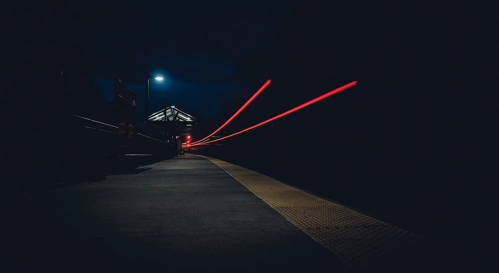 A night-time shot displaying two mysterious red light trails and a dim streetlight. Original public domain image from…