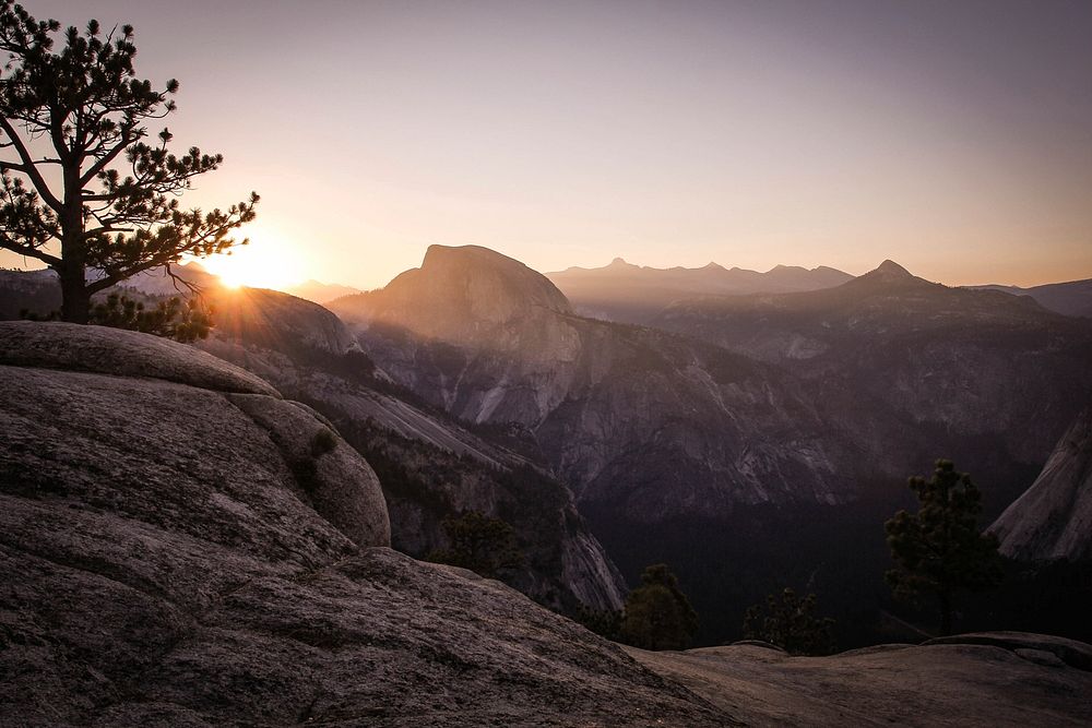 A sun setting over the granite hills of Half Dome in Yosemite Valley, Yosemite National Park. Original public domain image…