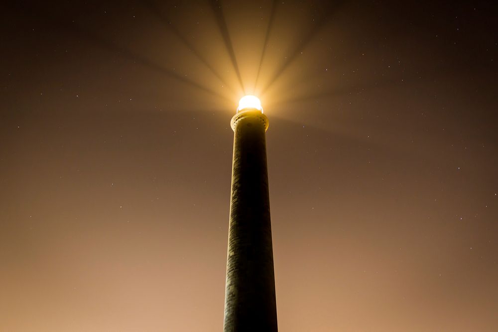 A lighthouse during night time. Original public domain image from Wikimedia Commons