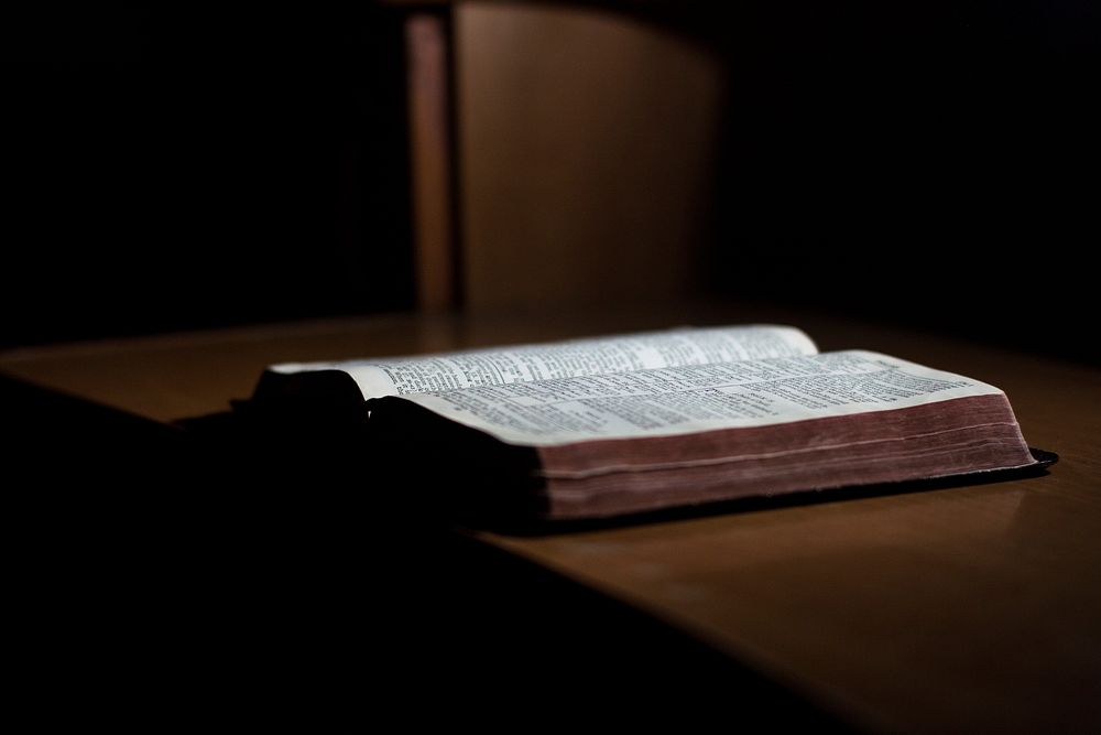 An opened book on a desk. Original public domain image from Wikimedia Commons