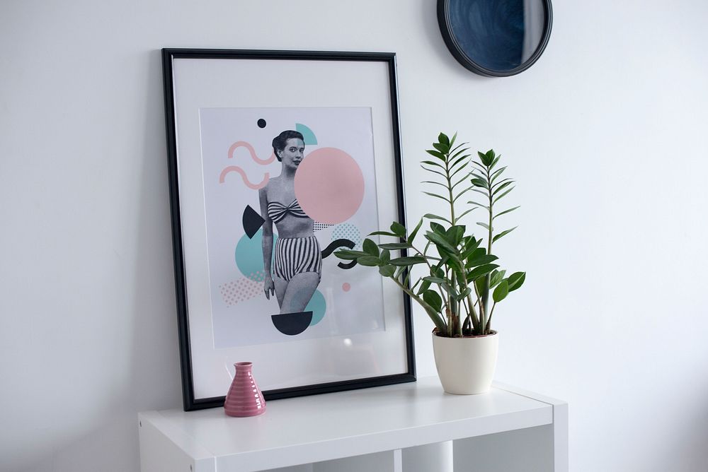 Interior with framed portrait of woman and potted plant on white table. Original public domain image from Wikimedia Commons