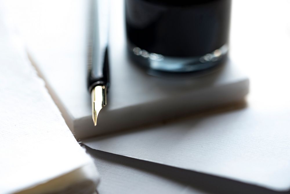 The glossy tip of a fountain pen next to a drinking glass. Original public domain image from Wikimedia Commons