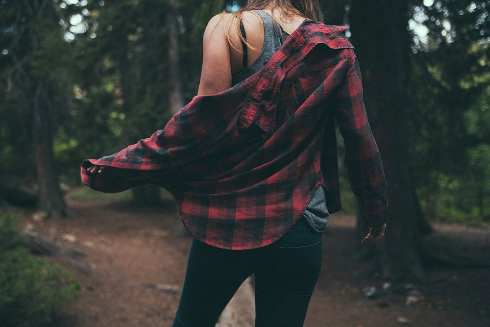 A woman taking off her flannel shirt in Big Cottonwood Canyon. Original public domain image from Wikimedia Commons