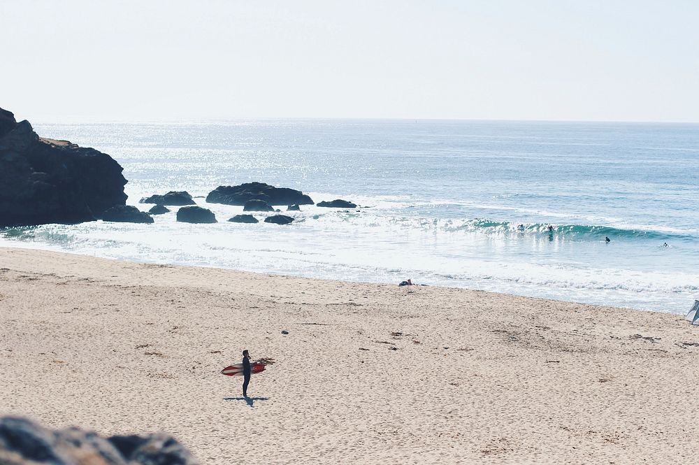 Surfer standing on sandy beach., Montara Beach, California. Original public domain image from Wikimedia Commons