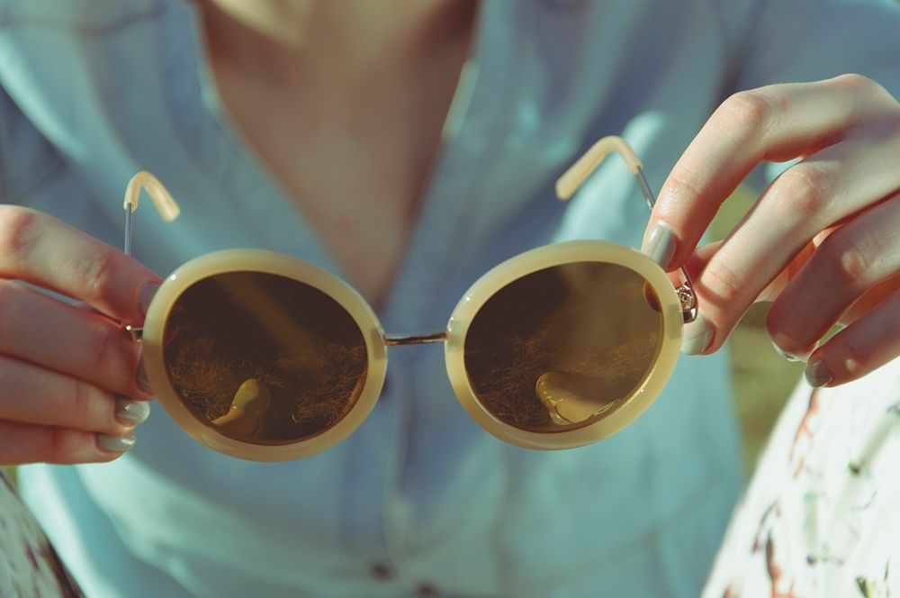 Woman holding round sunglasses in Poland. Original public domain image from Wikimedia Commons