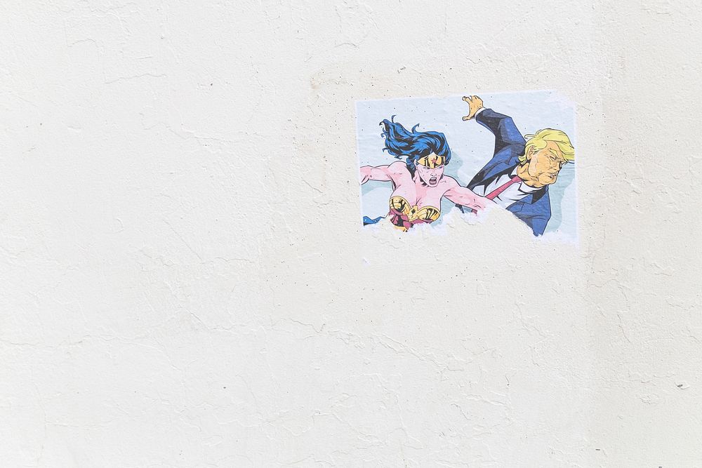 Wonder Woman punching Donald Trump street art on white wall in Center Street. Original public domain image from Wikimedia…