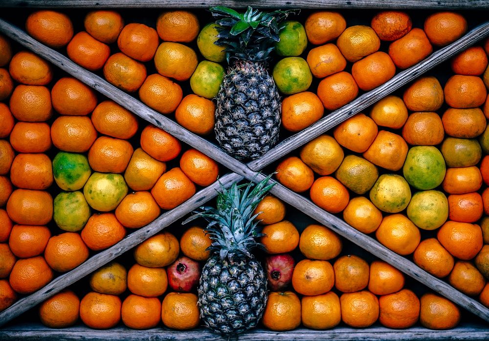 Top view of a fruit bin featuring pineapples and other fruits.. Original public domain image from Wikimedia Commons