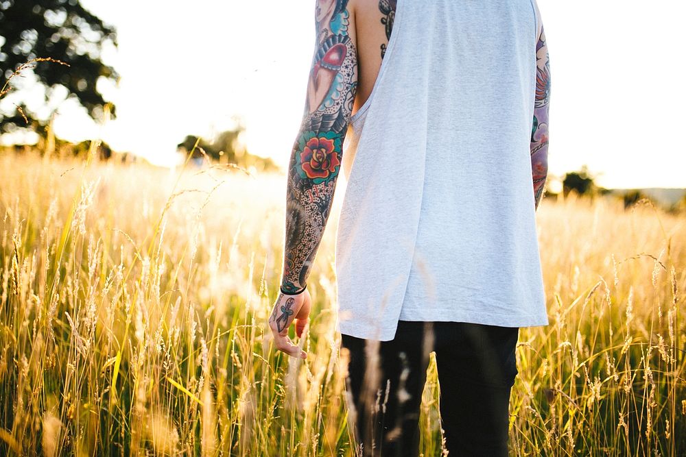 A man with tattoos in the field. Original public domain image from Wikimedia Commons