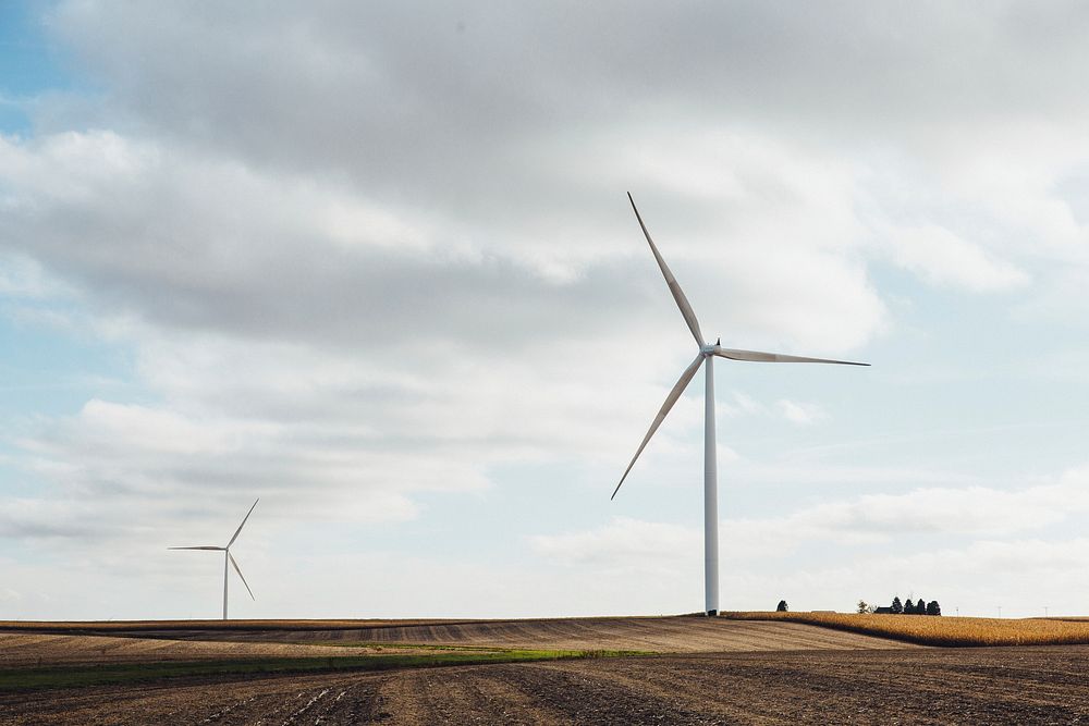 Wind turbines create green energy in a farm field. Original public domain image from Wikimedia Commons