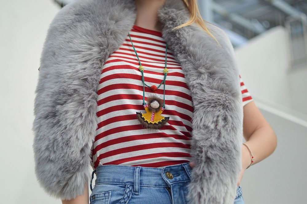 Torso of a trendy woman in a fashioanble fur coat and doll necklace. Original public domain image from Wikimedia Commons