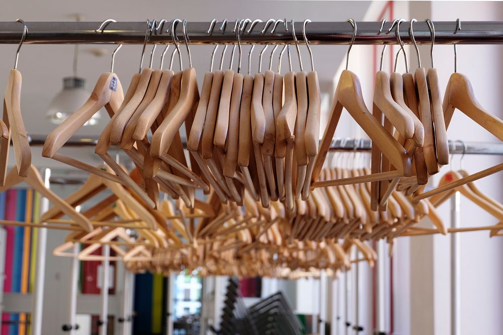 Coat hangers on a rail in a clothing store. Original public domain image from Wikimedia Commons