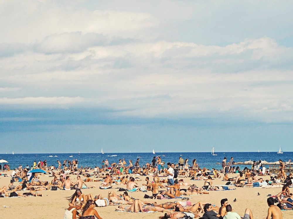 Beach is crowded with people on tourism enjoying the summer holiday and vacation in Barcelona. Original public domain image…
