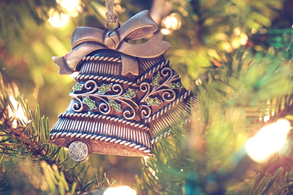 A Christmas ornament shaped like two bells hanging from a tree. Original public domain image from Wikimedia Commons