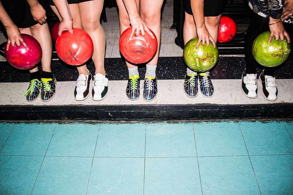 A group of people holding bowling balls lining up in a row. Original public domain image from Wikimedia Commons