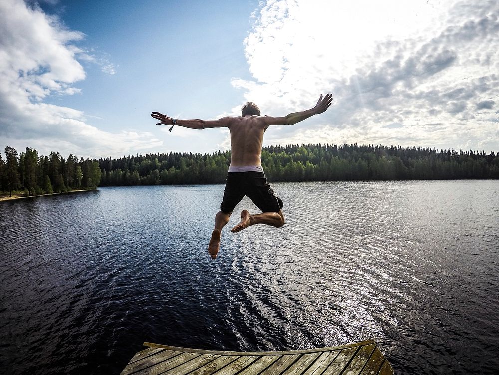 A man leaping into a lake from a pier. Original public domain image from Wikimedia Commons