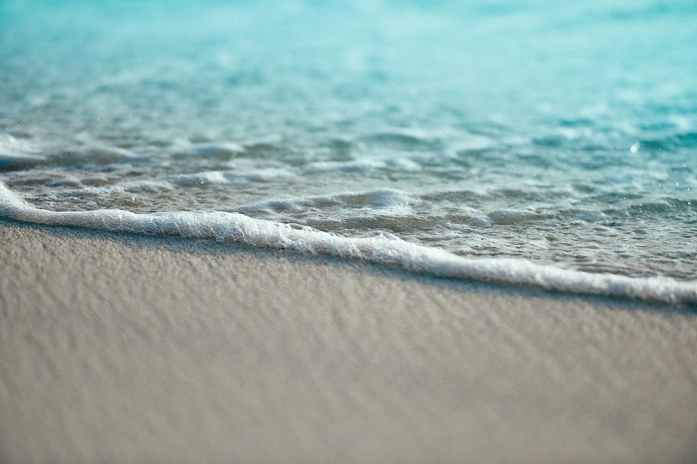 Ocean foam washing on a sand beach in Kudafari. Original public domain image from Wikimedia Commons