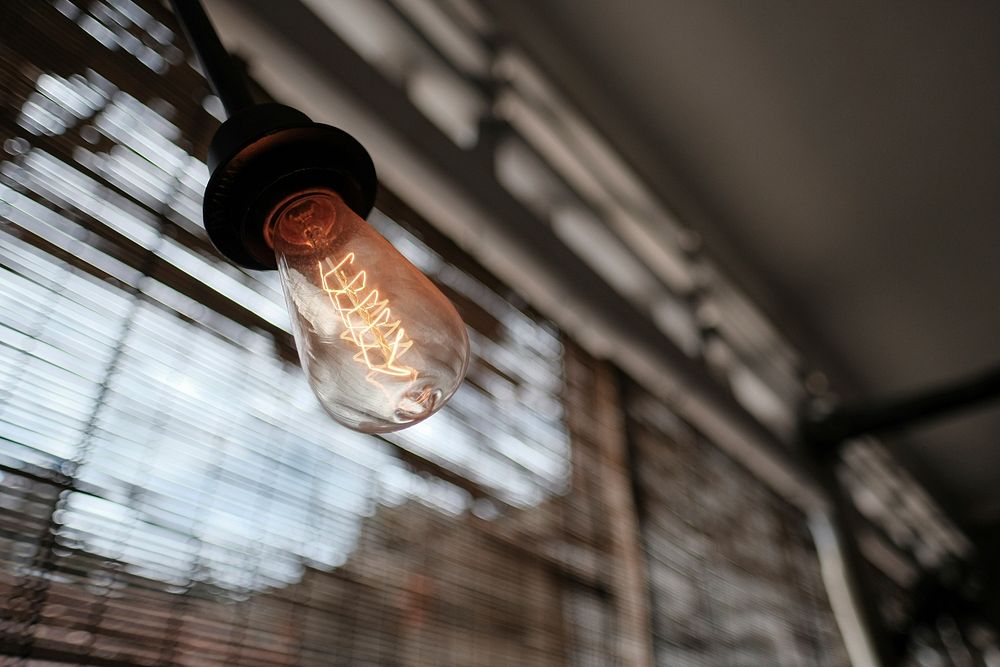 Burning filament in a light bulb near a window. Original public domain image from Wikimedia Commons