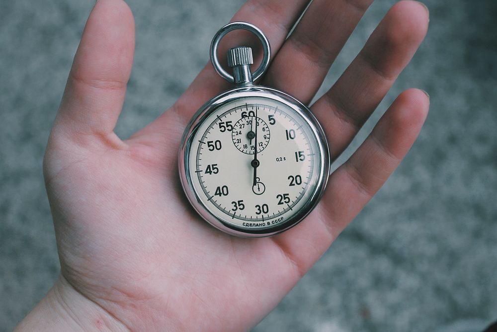 A pocket watch in a person's open hand. Original public domain image from Wikimedia Commons