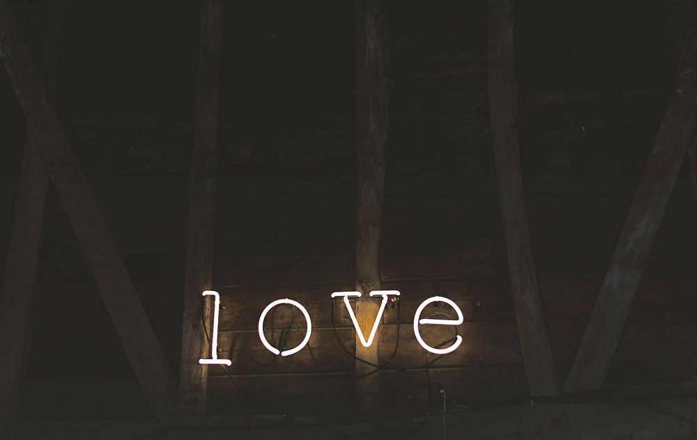 Neon lights spell out love against a wooden barn wall. Original public domain image from Wikimedia Commons