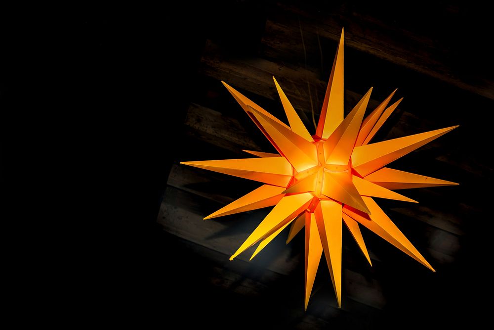 An orange decoration in the shape of multi-pointed star hanging from a ceiling. Original public domain image from Wikimedia…
