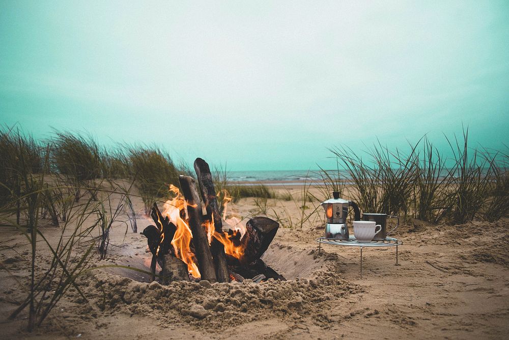 Kettle and a cup on a stand by the large fire in the sand hole. Original public domain image from Wikimedia Commons