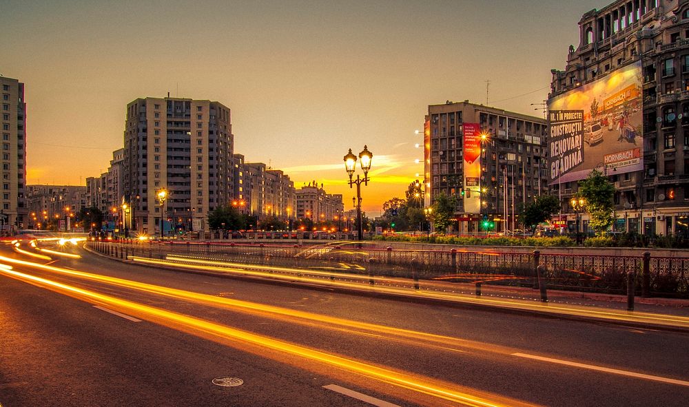 Orange light trails in the streets of a Romanian city during sunset. Original public domain image from Wikimedia Commons