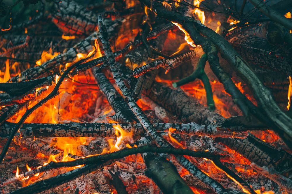 Hot embers and flames in a fire pit filled with firewood and twigs at Wydale Hall & Emmaus Centre. Original public domain…