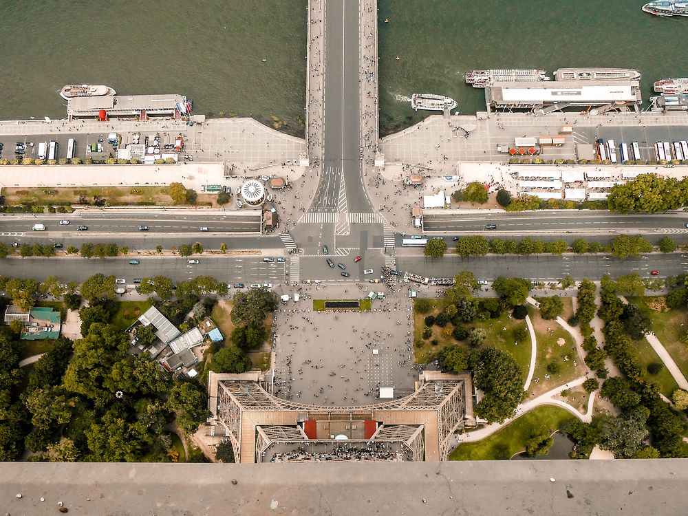 Aerial drone view looking down onto intersection, trees, and pedestrians from Eiffel Tower.. Original public domain image…
