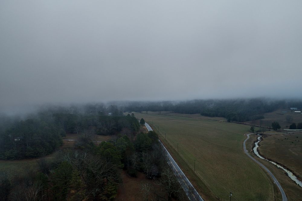 Aerial drone shot of rural fields and trees on a foggy day. Original public domain image from Wikimedia Commons