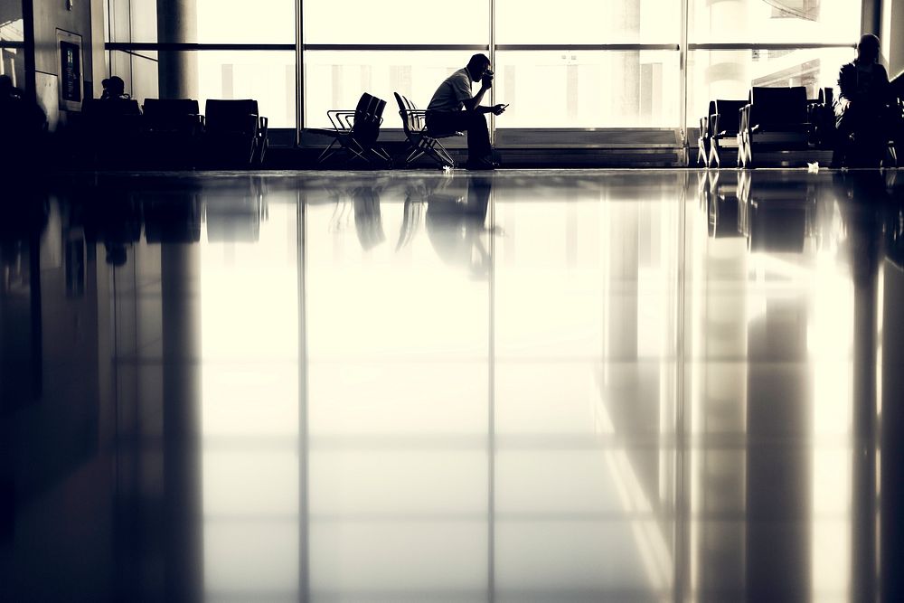 A man waiting in a chair at the airport. Original public domain image from Wikimedia Commons
