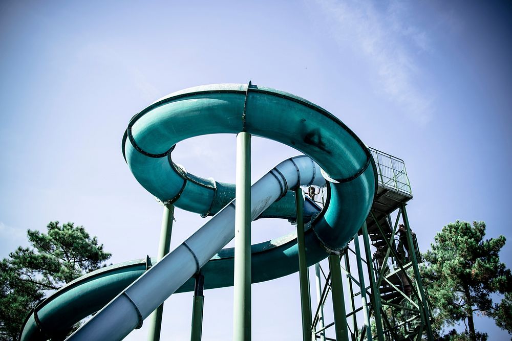Looking up at a blue and teal tube water slide in Labenne. Original public domain image from Wikimedia Commons