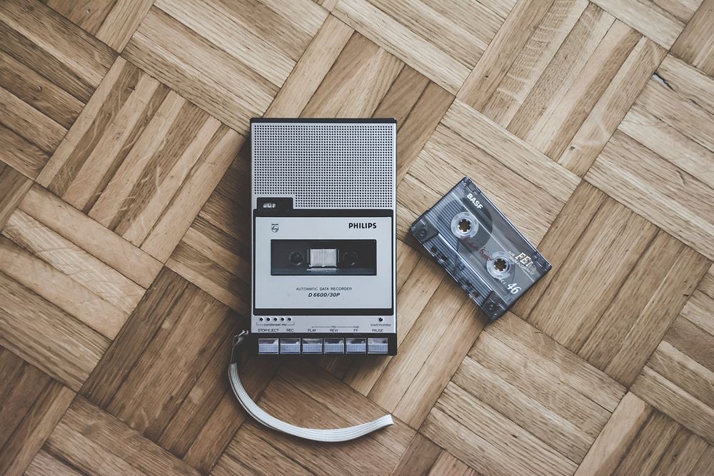 An old cassette player and tape laying on a wooden floor in Italy. Original public domain image from Wikimedia Commons